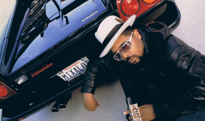 Sir Mix-a-Lot crouching behind a Lamborghini Diablo with a "MIXALOT" Washington license plate.