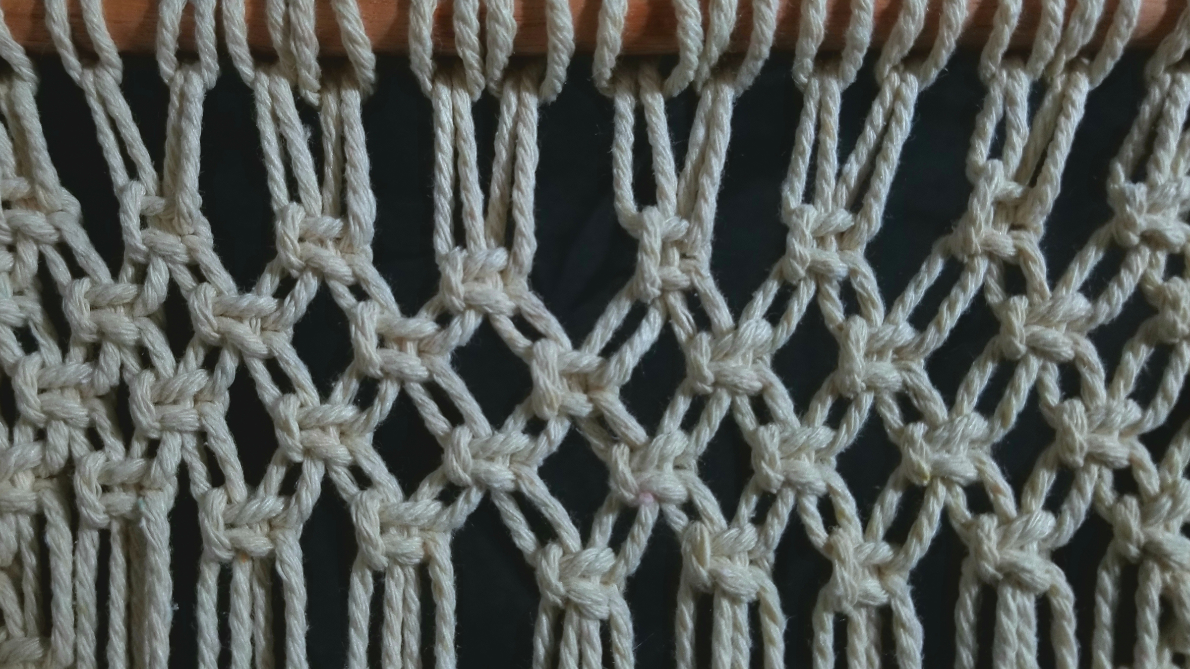 A close up of white yarn being used in macrame.