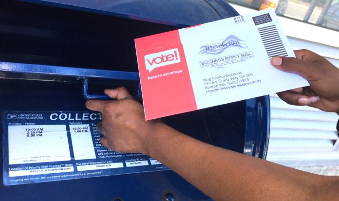 Voter places voting pamphlet in mailbox.
