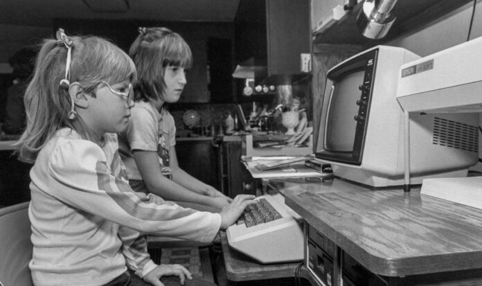 Two children using an Apple II computer.