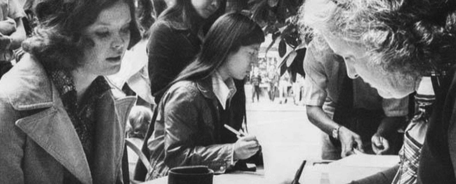 A black and white photo of women voting.