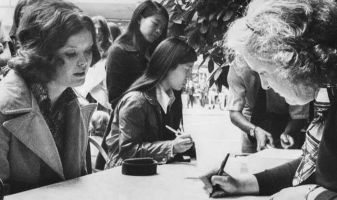 A black and white photo of women voting.