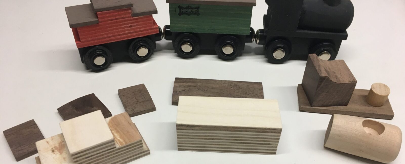 A collection of wooden trains and the components to build one.