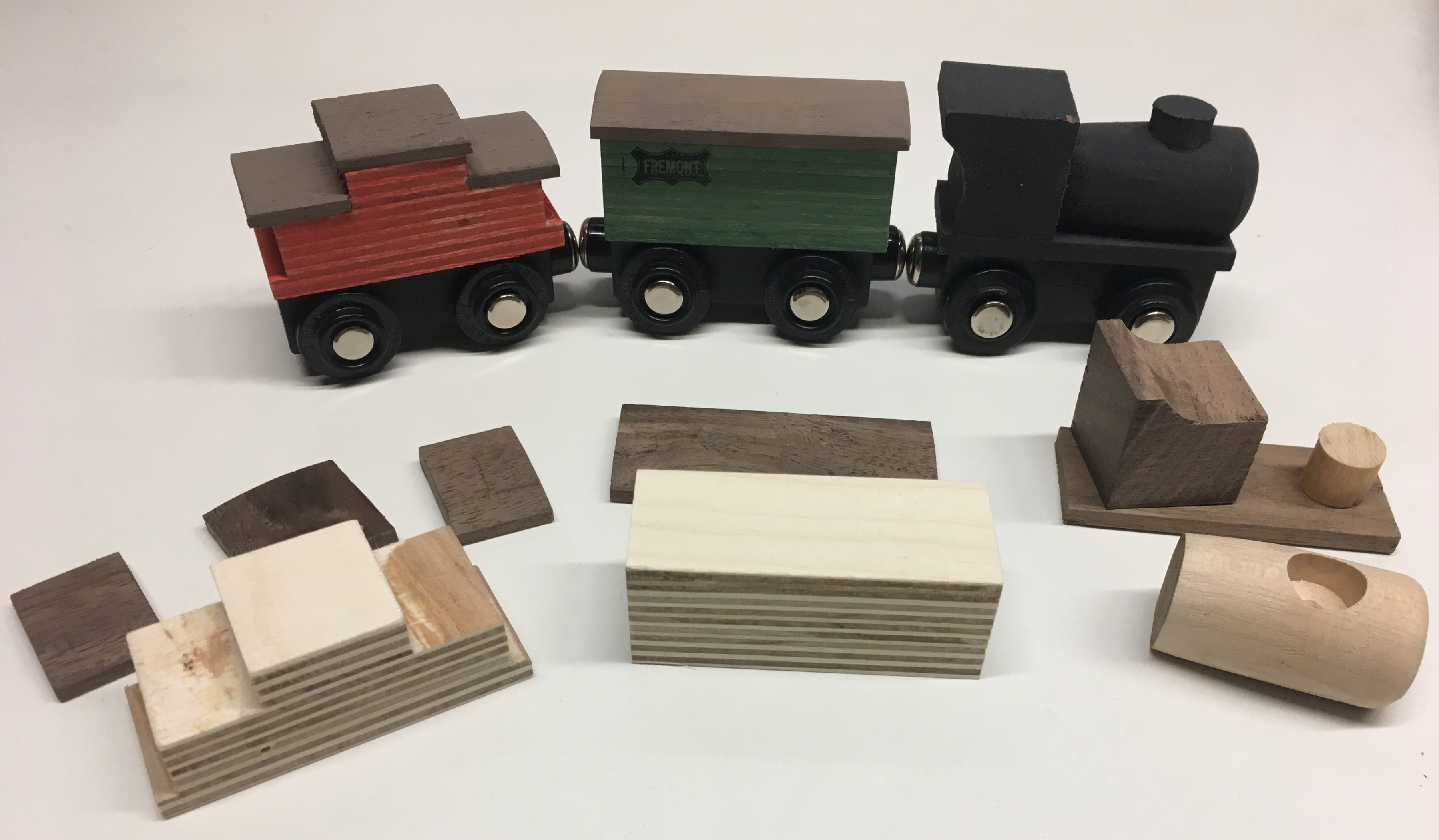 A collection of wooden trains and the components to build one.