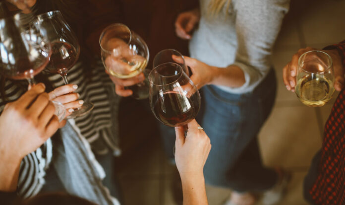 A top-down view of six people holding glasses of red and white wine.