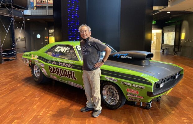 Al Young standing in front of his green and black Dodge Challenger in the Grand Atrium at MOHAI.