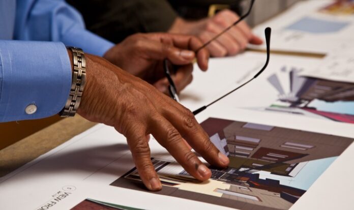 A hand presses down on several architecture images.