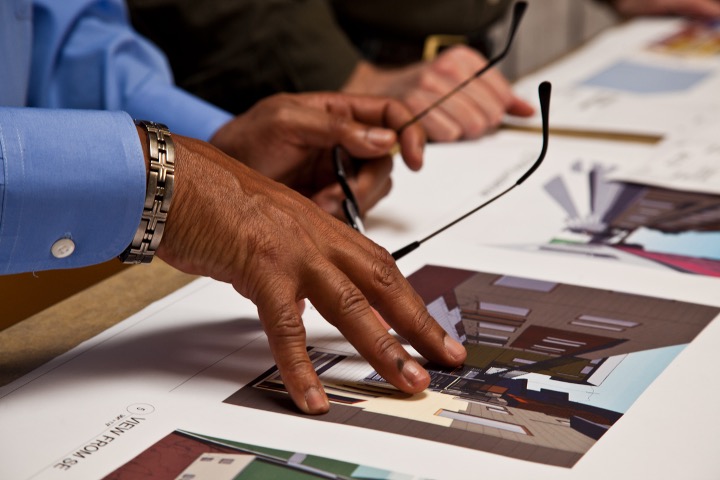 A hand presses down on several architecture images.