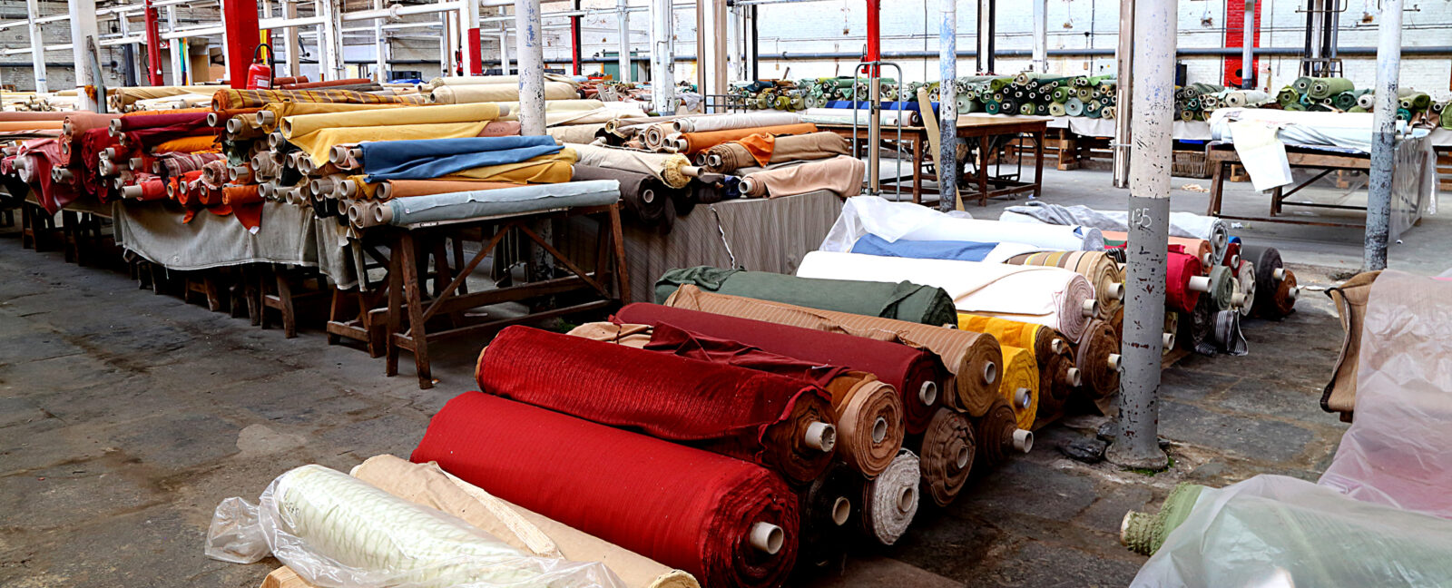 A factory with numerous rolls of fabric neatly stacked on shelves