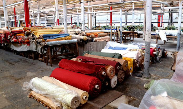 A factory with numerous rolls of fabric neatly stacked on shelves