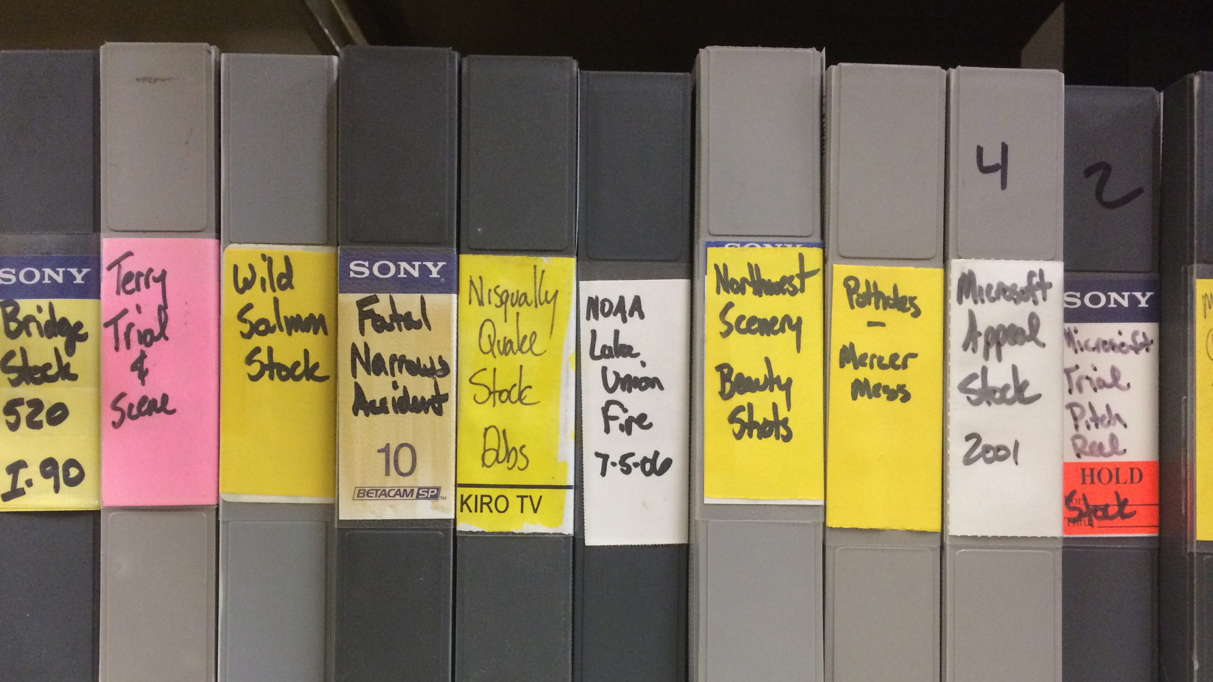 A row of grey binders on a shelf from the KIRO-TV archives.