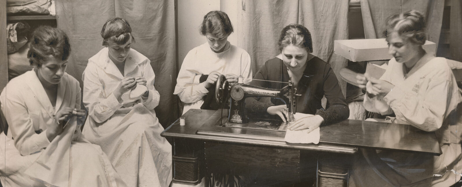 five Seattle members of the National Girl's Honor Guard sew layettes for babies