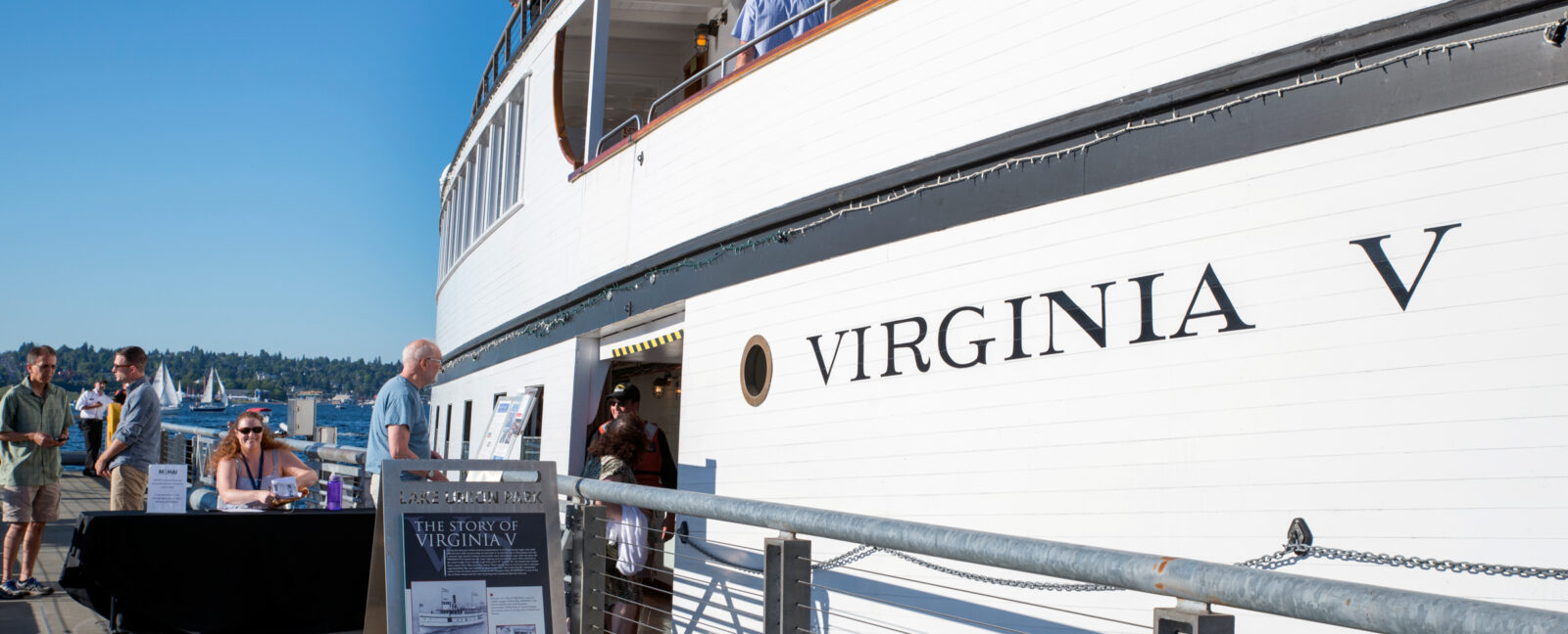 People bordering the SS Virginia V docked in Lake Union on a sunny day in Seattle