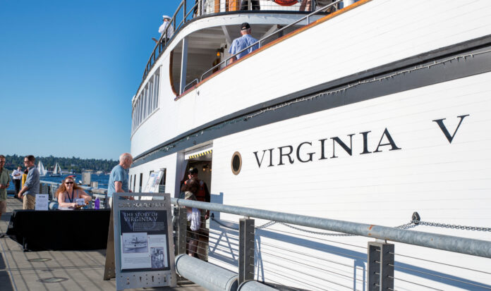 People bordering the SS Virginia V docked in Lake Union on a sunny day in Seattle