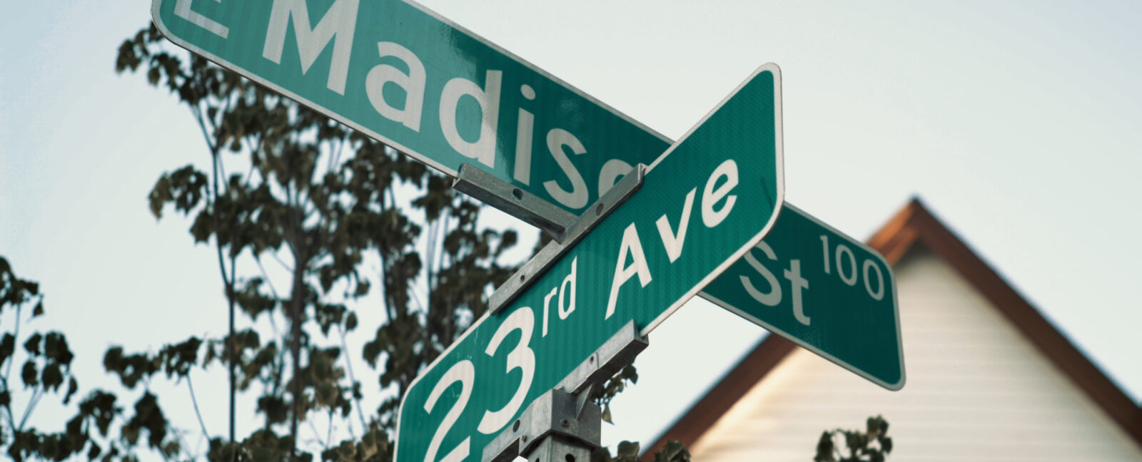 Street signs for E Madison Street and 23rd Avenue.