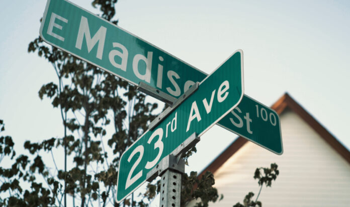 Street signs for E Madison Street and 23rd Avenue.