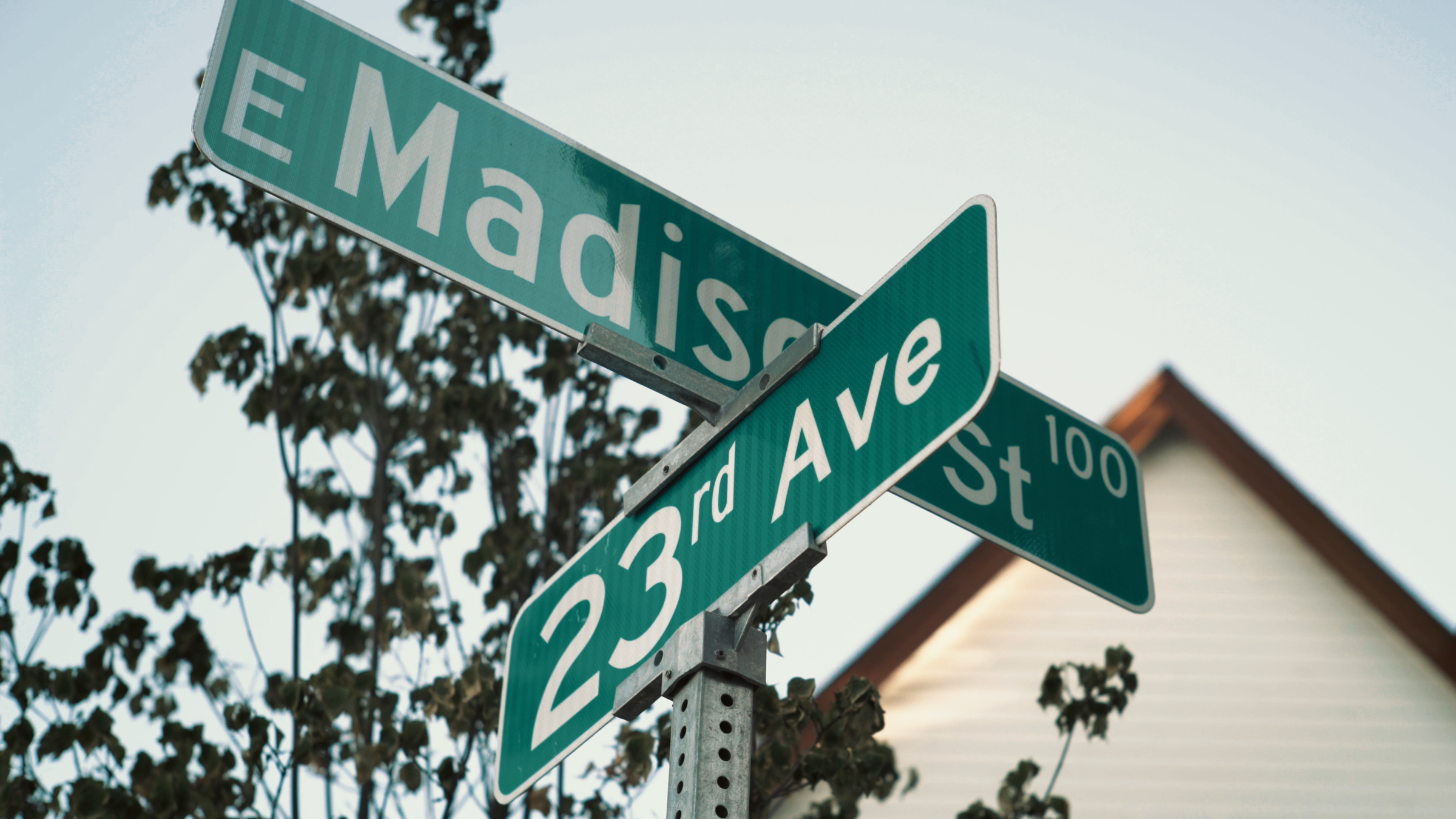 Street signs for E Madison Street and 23rd Avenue.
