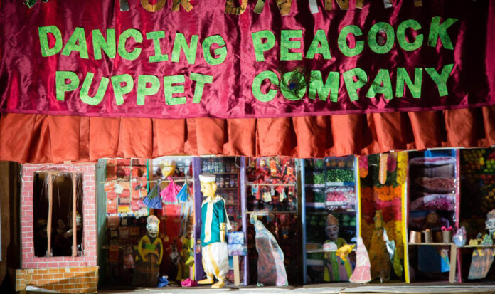 Dancing Peacock Puppet Company banner with puppet and stage below.