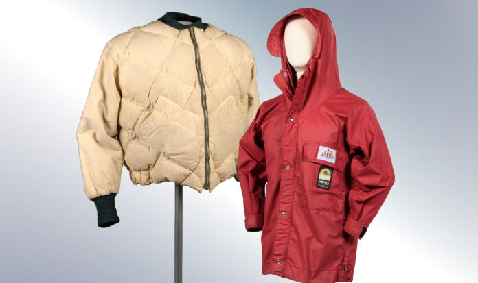 Two coats on display. The left coat is cream colored. The right coat has a hood and is red colored.