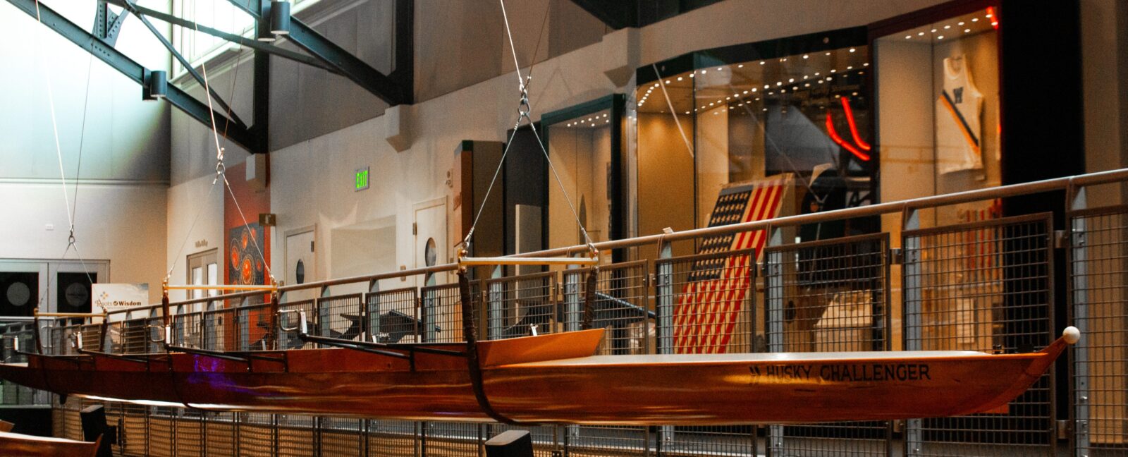 The Husky Challenger racing shell hanging in the Grand Atrium at MOHAI. The United States flag is visible in the background.