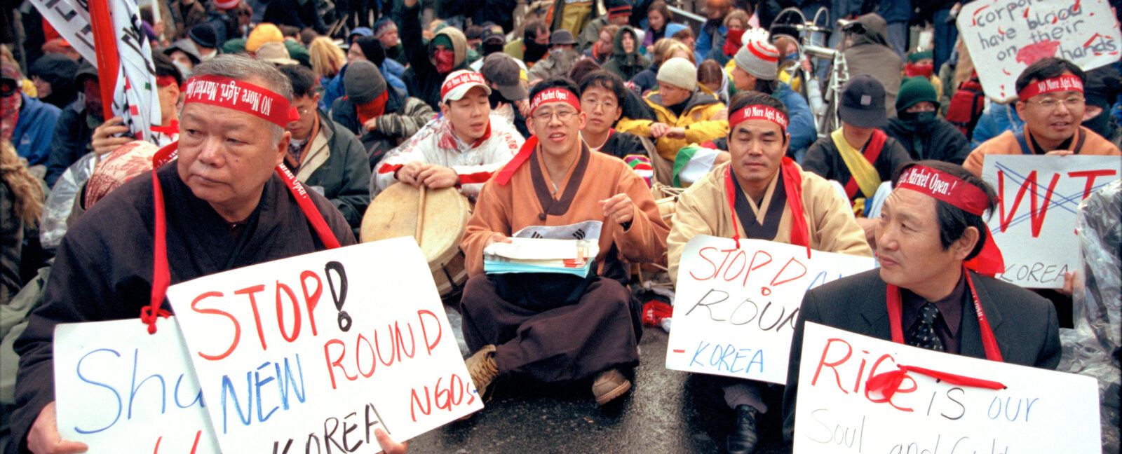 Korean farmers sit in the street with protest signs at WTO protest, Seattle, November 30, 1999.