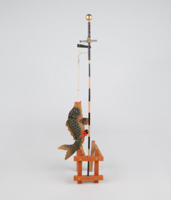 Photograph of a Japanese carp fish doll hanging from a pole.