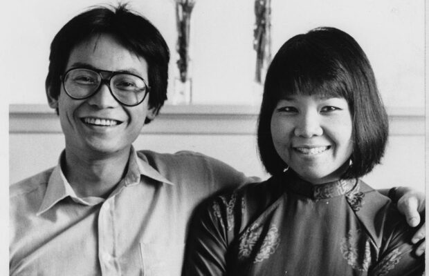 Black and white photograph of Duong Tran and Kimlien Tran sitting together on a couch and smiling.
