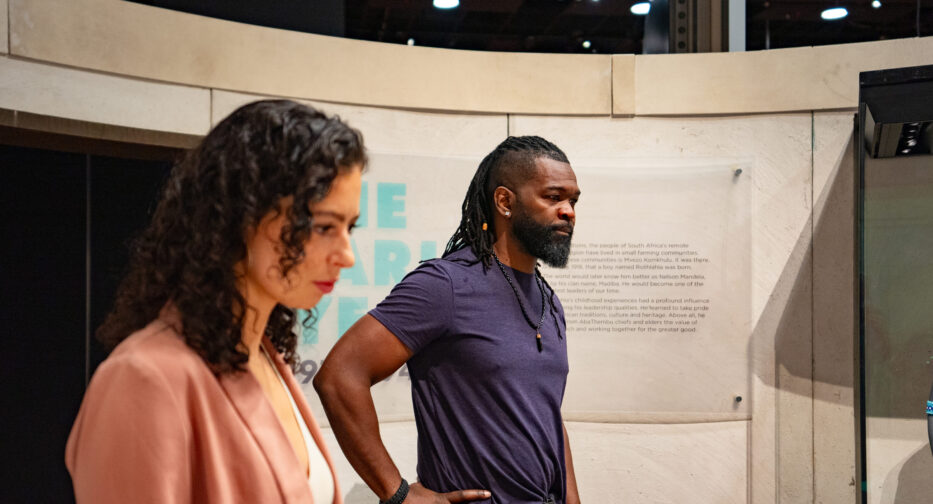 Visitors to the Mandela exhibit taking in The Struggle is My Life, a gallery filled with powerful imagery capturing the harsh realities of apartheid and the resilience of those who fought against it.