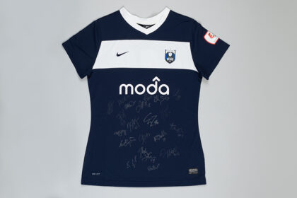 Seattle Reign FC blue soccer jersey with white signatures from players across the front.