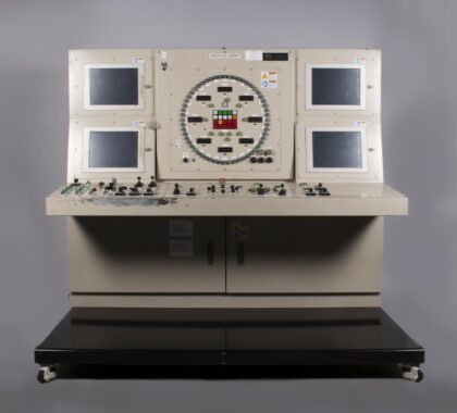 Control panel from the Seattle Tunnel Boring Machine with multiple monitors, switches, and joysticks used for machine operations.
