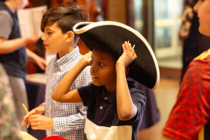 Boy wearing pirate hat enjoys a class field trip at MOHAI in Seattle, WA.