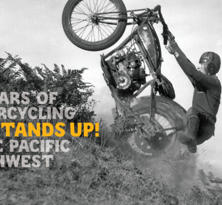 Kickstands Up! Motorcycle doing a wheelie up a dirt hill.