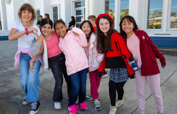 A group of six children pose for a photo outside MOHAI in downtown Seattle, WA.