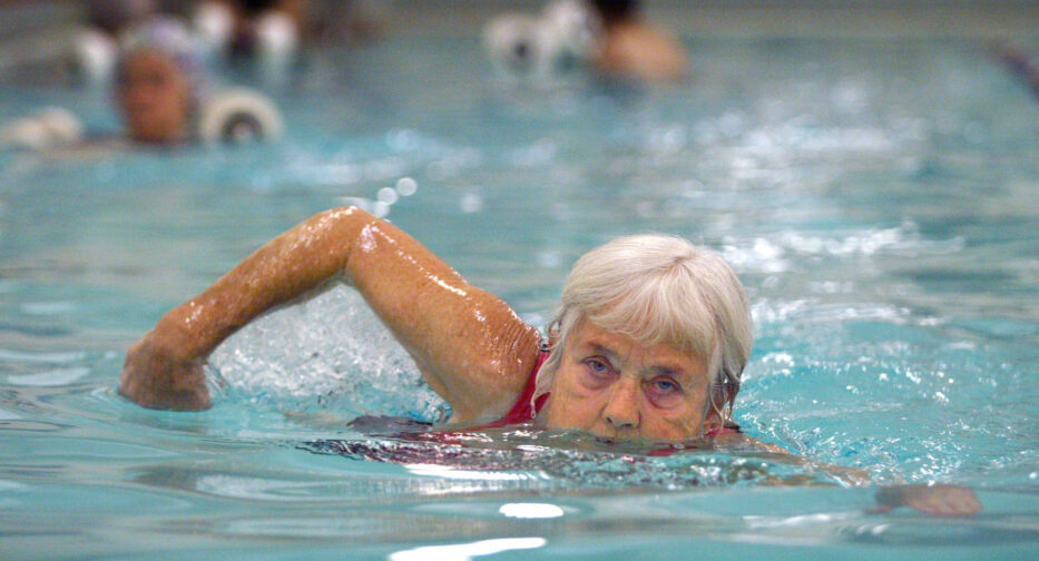 Color photograph of Jeanne Wharnsby swimming laps at the downtown Seattle YWCA pool.