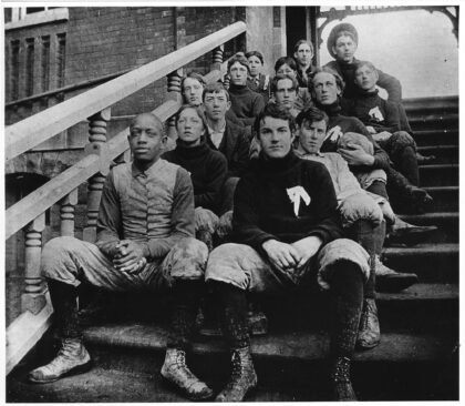 Football team sitting on steps at South School, circa 1896