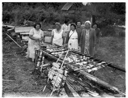 A group of Indigenous women cooking salmon over a fire on the Muckleshoot Reservation.
