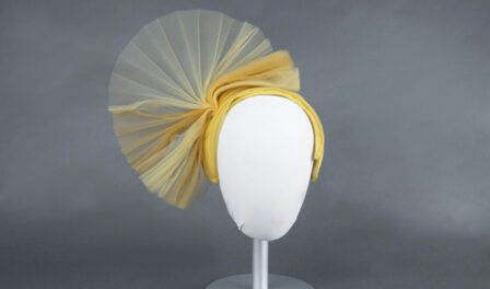 Yellow hat designed by John Eaton, 1960s displayed on a white mannequin head.
