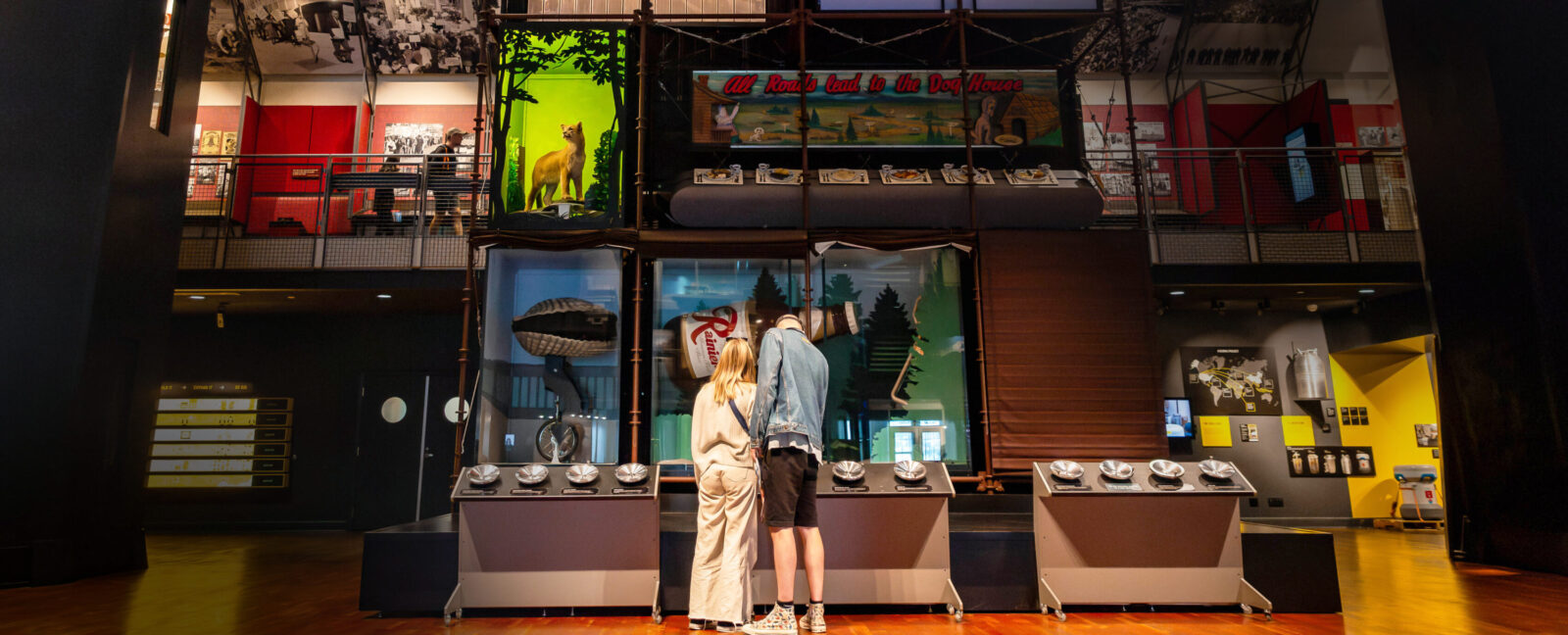 A couple stands in the Grand Atrium at MOHAI engaging with an exhibit.