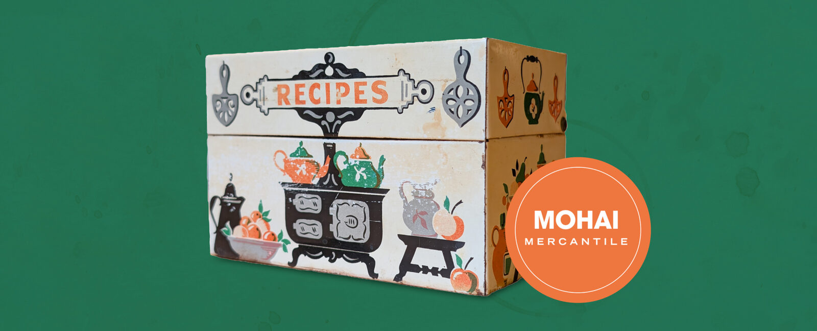An antique recipe box against a green background.