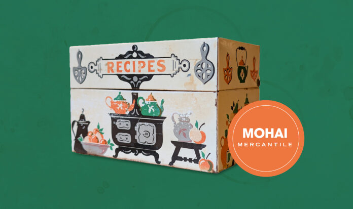 An antique recipe box against a green background.