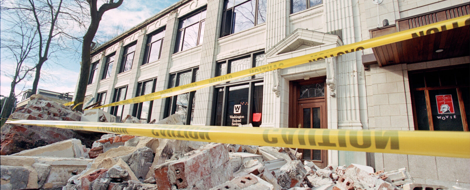 Exterior of the Washington Federal Savings building in Seattle, WA. Brick rubble and yellow caution tape is seen in the foreground.
