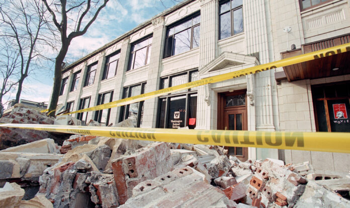 Exterior of the Washington Federal Savings building in Seattle, WA. Brick rubble and yellow caution tape is seen in the foreground.