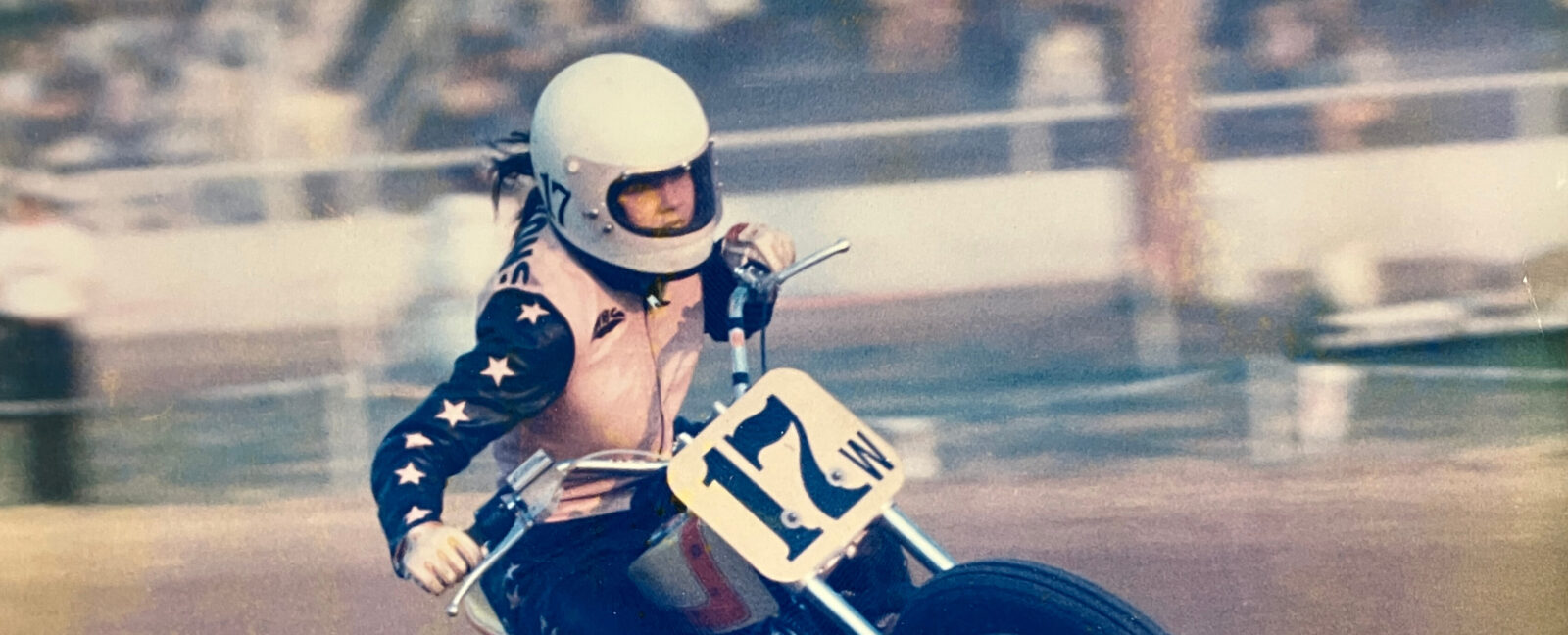 Tammy Sessions riding a motorcycle in a pink leather jacket.