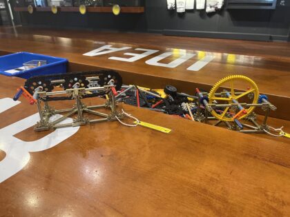A collection of LEGO Technic pieces displayed on a wooden table.