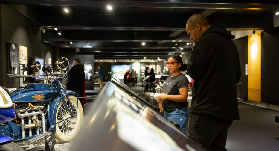 Two visitors engaging with the Kickstands Up! exhibit at MOHAI in downtown Seattle, WA.