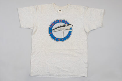 Photograph of a gray t-shirt with a logo that reads "friends of the monorail" with an image of the Seattle Monorail in the center.