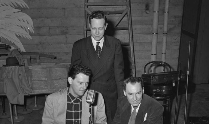 Woody Herman, right, and two unidentified men sit near a microphone for an interview with KRSC radio, backstage at the Civic Auditorium at 321 Mercer Street.