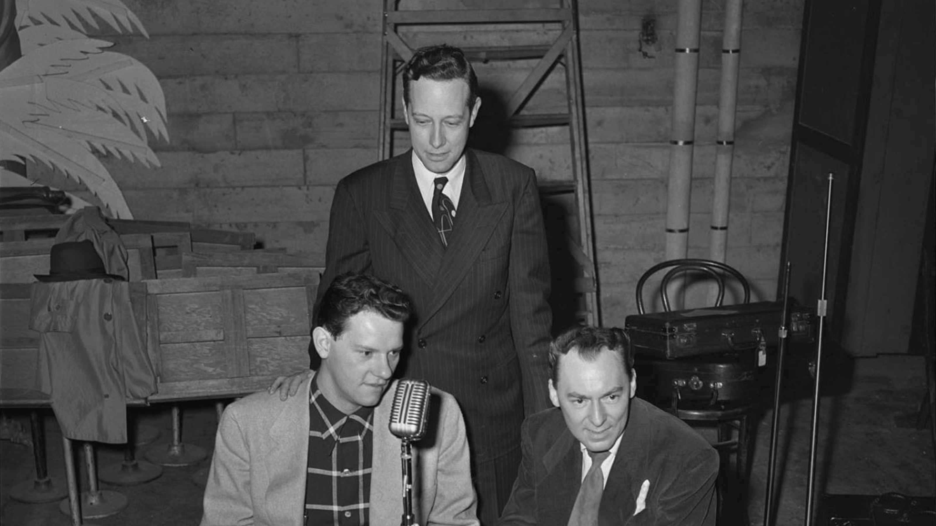 Woody Herman, right, and two unidentified men sit near a microphone for an interview with KRSC radio, backstage at the Civic Auditorium at 321 Mercer Street.