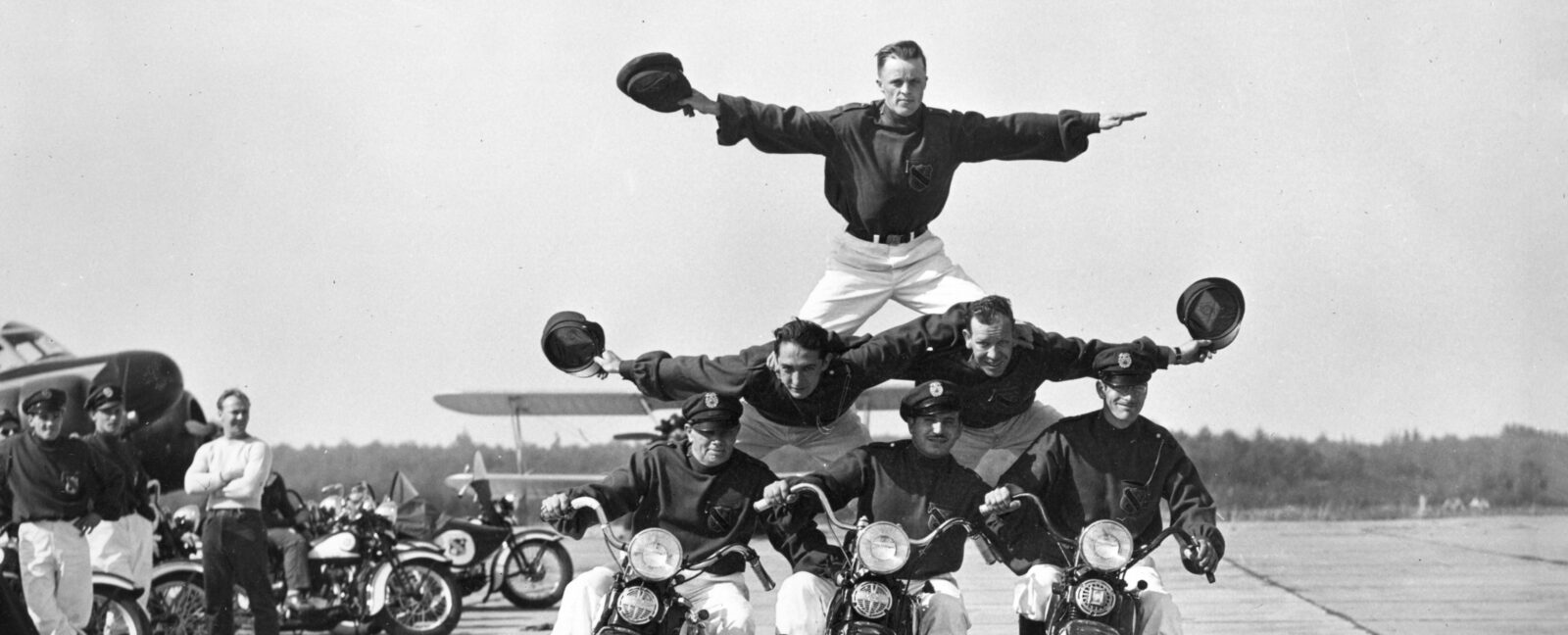 Six members of the Seattle Cossacks Stunt and Drill Team form a pyramid while riding three motorcycles.