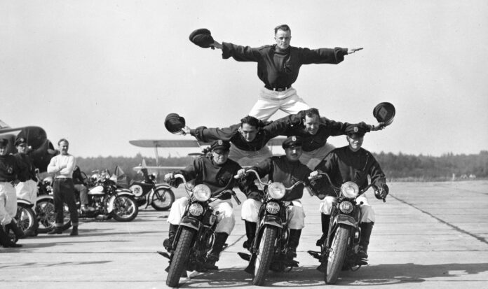 Six members of the Seattle Cossacks Stunt and Drill Team form a pyramid while riding three motorcycles.